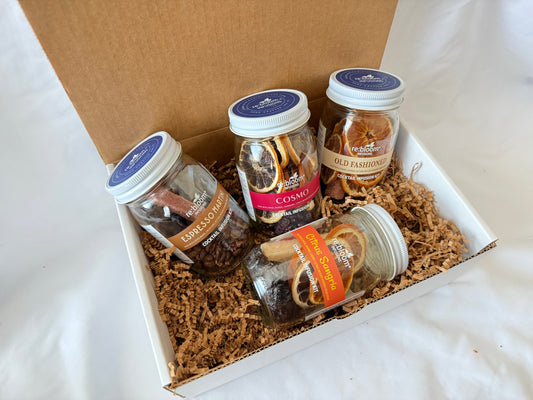 Four jars of cocktail infusion jar mix in a box on a white surface