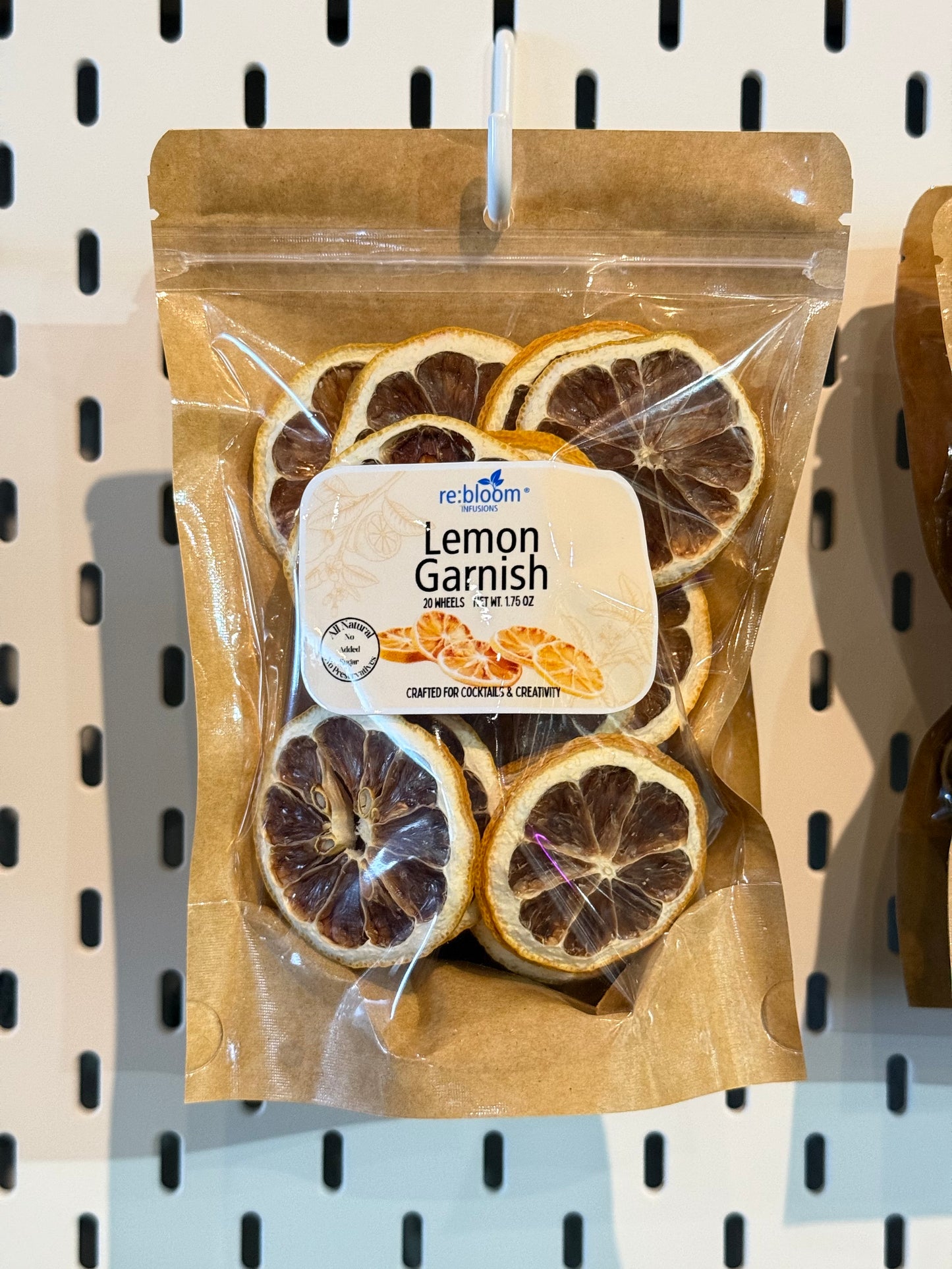 Packaged lemon garnish with a visible brand label on a pegboard background
