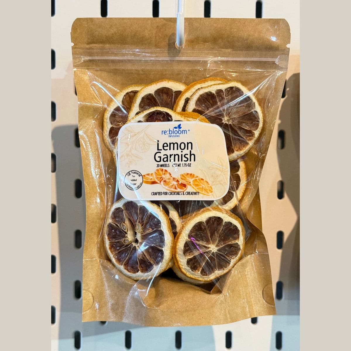 Dehydrated lemon garnish slices packaged for cocktails and mocktails displayed on a pegboard