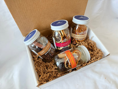 Four jars of cocktail infusion jar mix in a box on a white surface