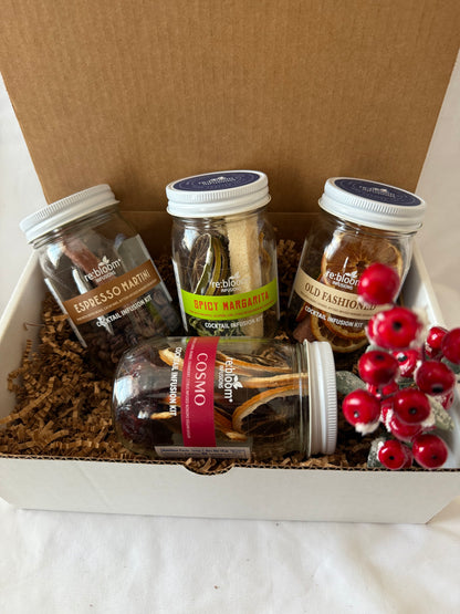 Assorted cocktail infusion kits with visible labels in a cardboard box.