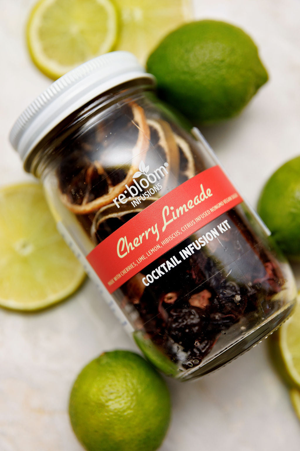 Cherry Limeade cocktail mocktail infusion kit with fresh citrus on a white background