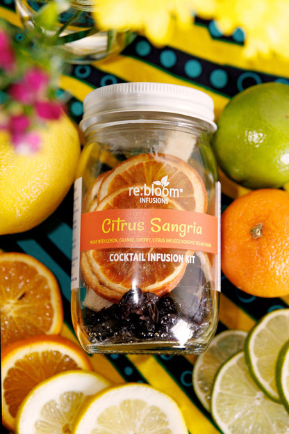 Citrus Sangria Cocktail infusion kit labeled 're:bloom' surrounded by citrus fruits on a colorful background