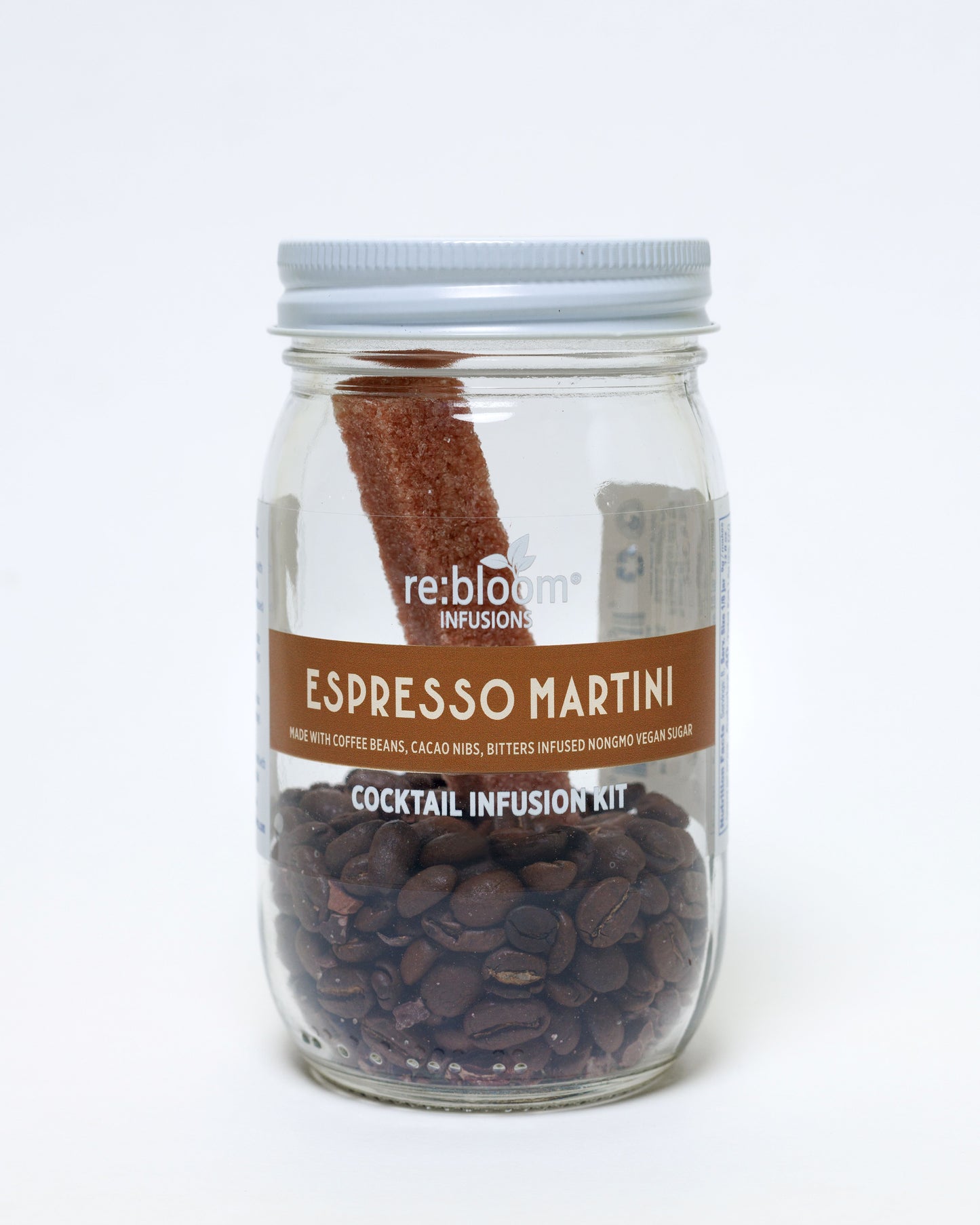 Espresso Martini cocktail infusion kit with coffee beans, cacao nibs and bitters infused sugar bar in a glass jar on a white background.