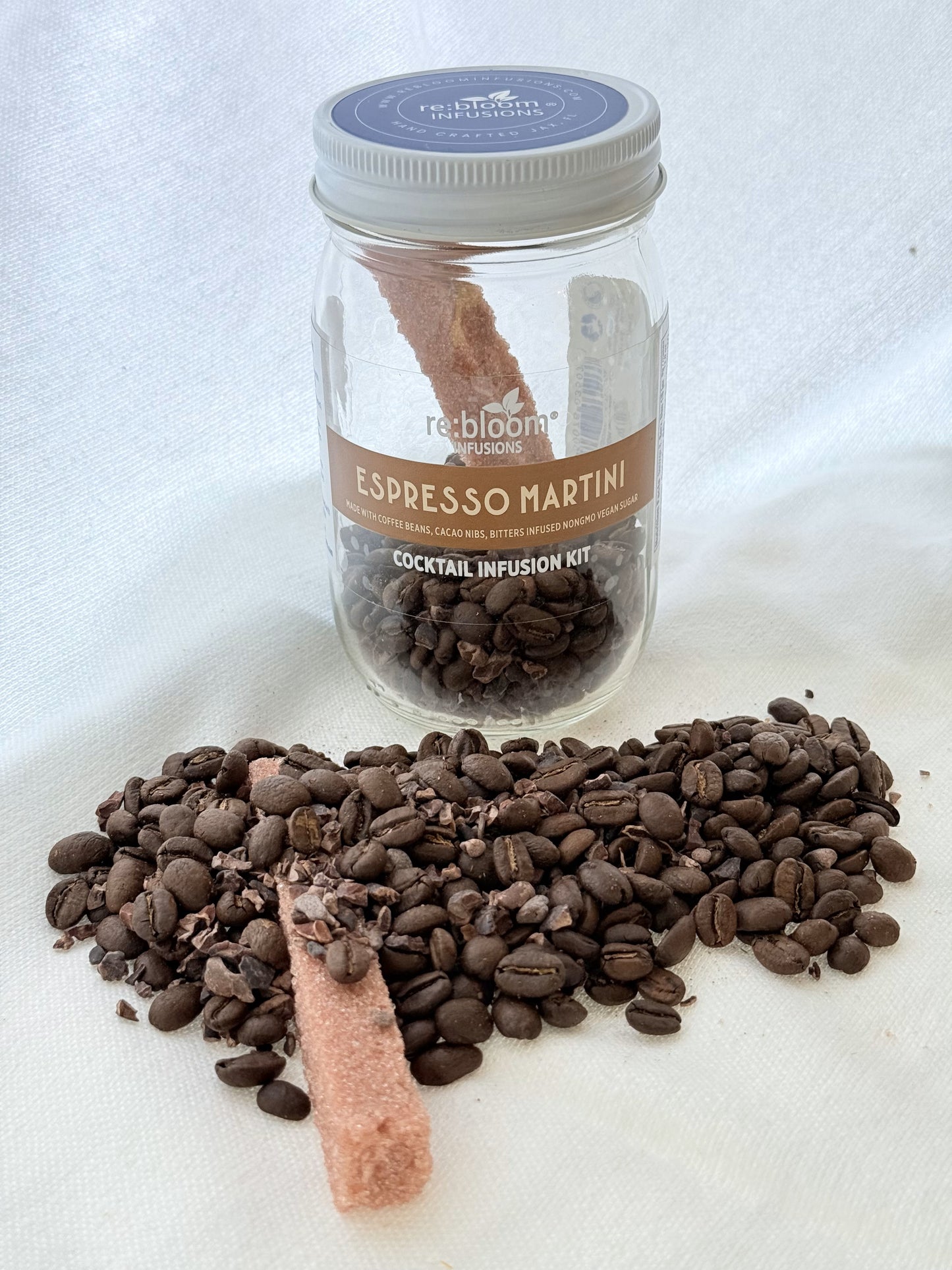Jar of Espresso Martini cocktail infusion kit with coffee beans, cacao nibbs and bitters infused sugar bar on a white background
