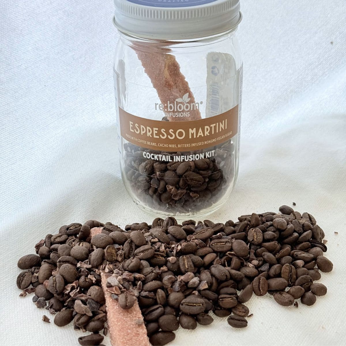 Espresso martini infusion kit jar with coffee beans and cacao nibs on white background