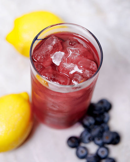 A complete made lavender berry lemonade ready to drink in a glass cup. 