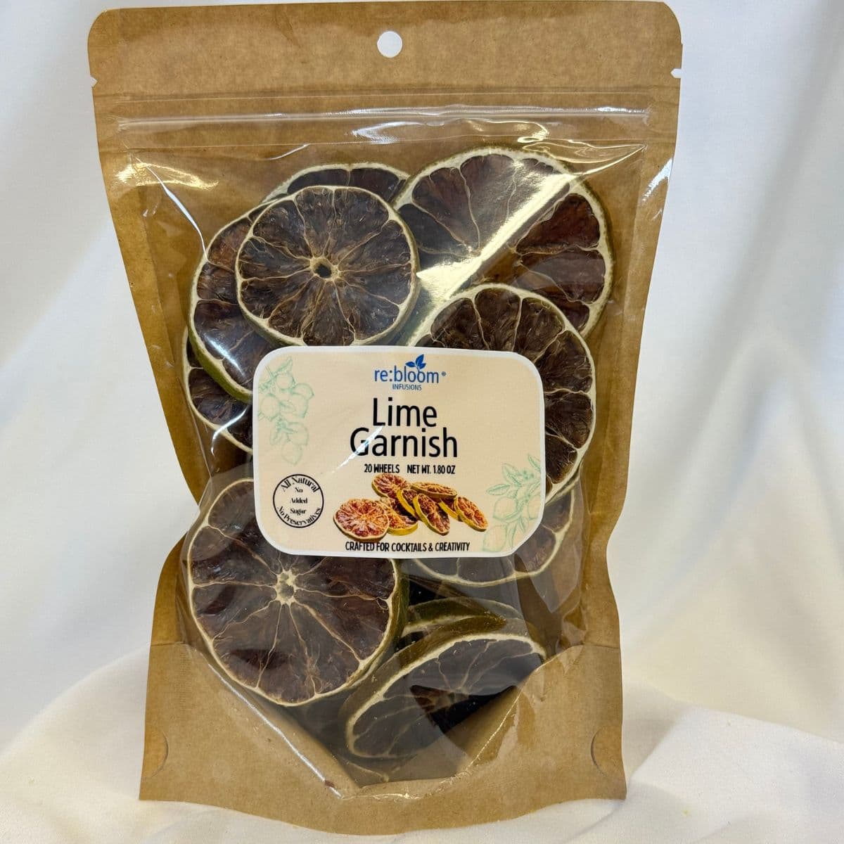 A package of Re: Bloom Lime Garnish dried lime slices in a brown kraft stand-up pouch with a clear window and a white label.