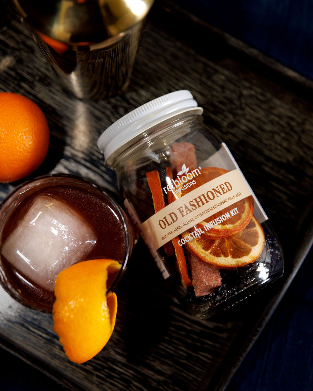 Old Fashioned cocktail kit with ingredients on a dark surface