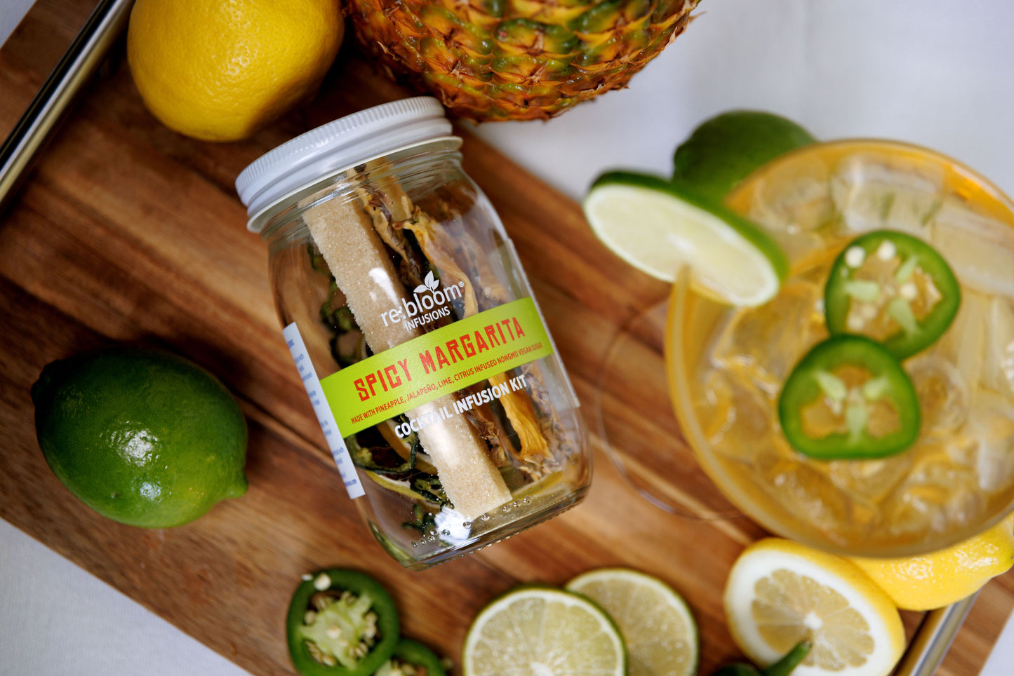 Spicy Margarita kit with lemons, limes, and jalapeños on a wooden board