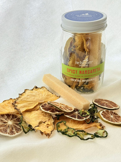 Jar of 'Spicy Margarita' cocktail infusion mix with dried citrus slices on a white background