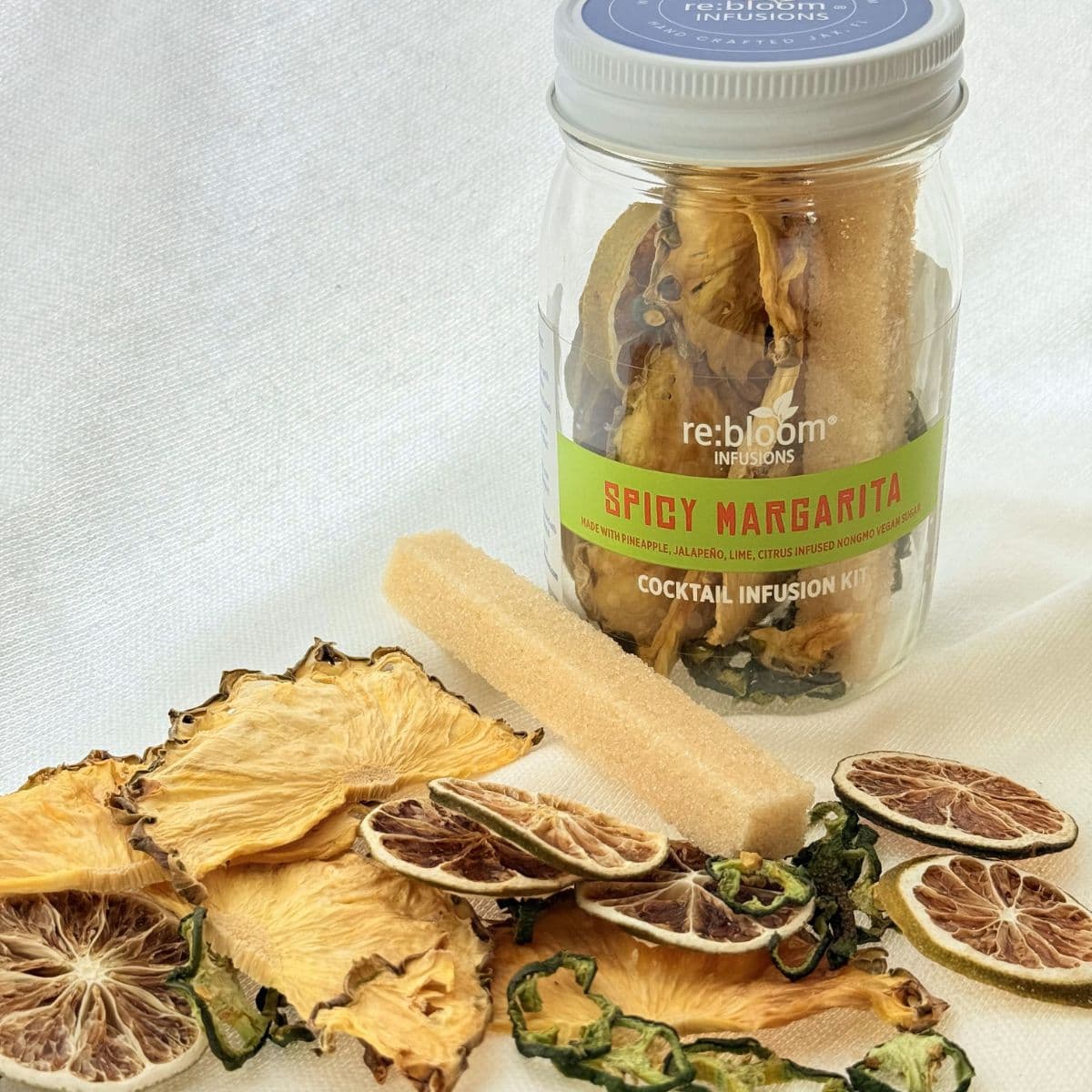 Spicy Margarita cocktail infusion kit with dried fruits and a rolling pin on a light background