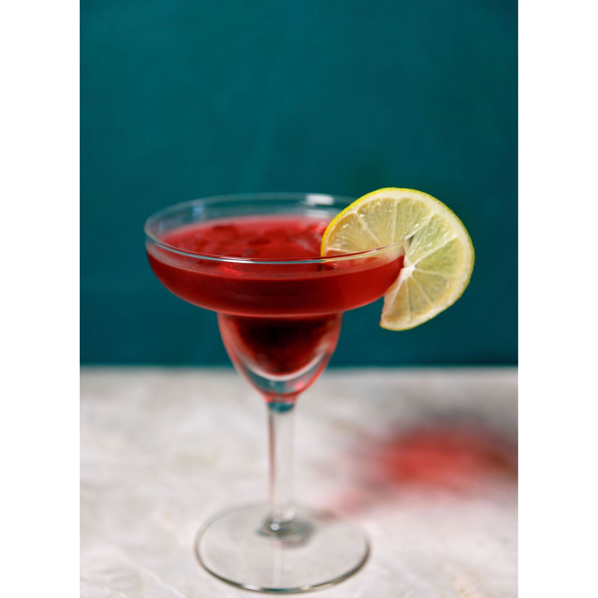 Cherry limeade cocktail with lime garnish in coupe glass made from infusion kit