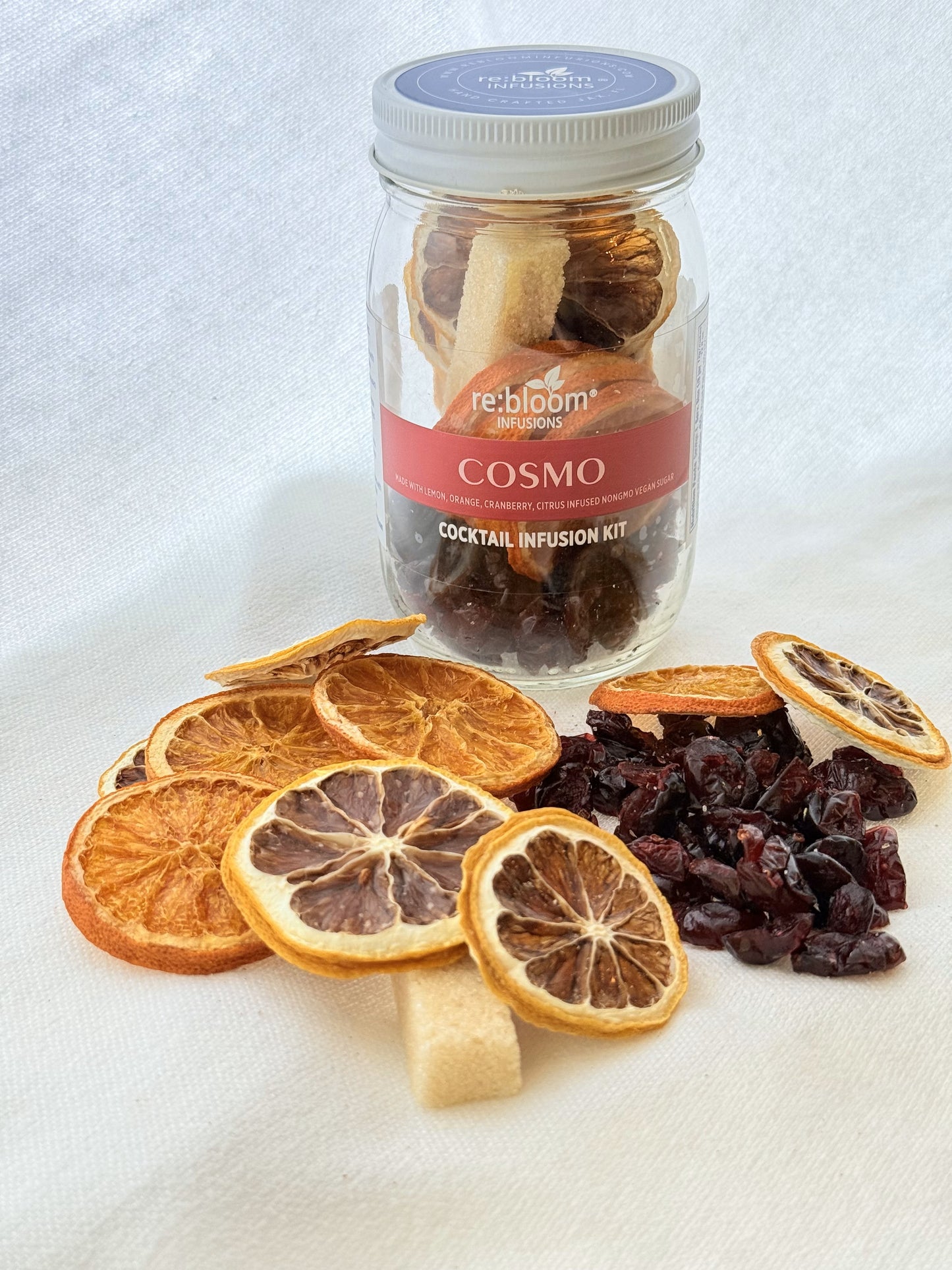Cocktail infusion kit with dried oranges and cherries on a white background