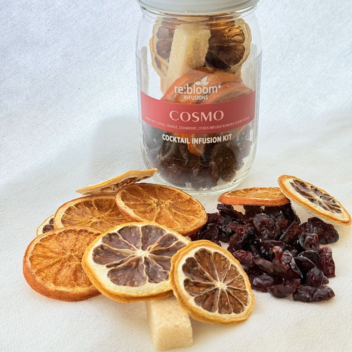 Cosmo cocktail infusion kit with dried citrus slices and cranberries on white background