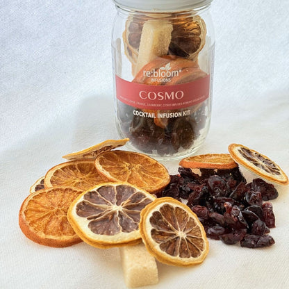 Cosmo cocktail infusion kit with dried citrus slices and cranberries on white background
