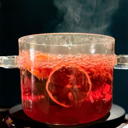 Floral blush simmer pot blend brewing on stovetop with dried orange slices and spices in glass pot