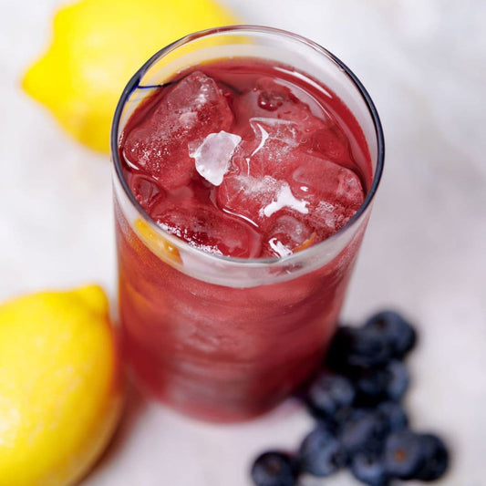Lavender berry lemonade cocktail with blueberries, lemon, and ice in glass made from infusion kit by Rebloom Infusions