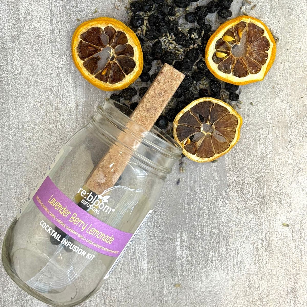 Lavender berry lemonade infusion kit ingredients with dried lemon slices, blueberries, and lavender in glass jar by Rebloom Infusions