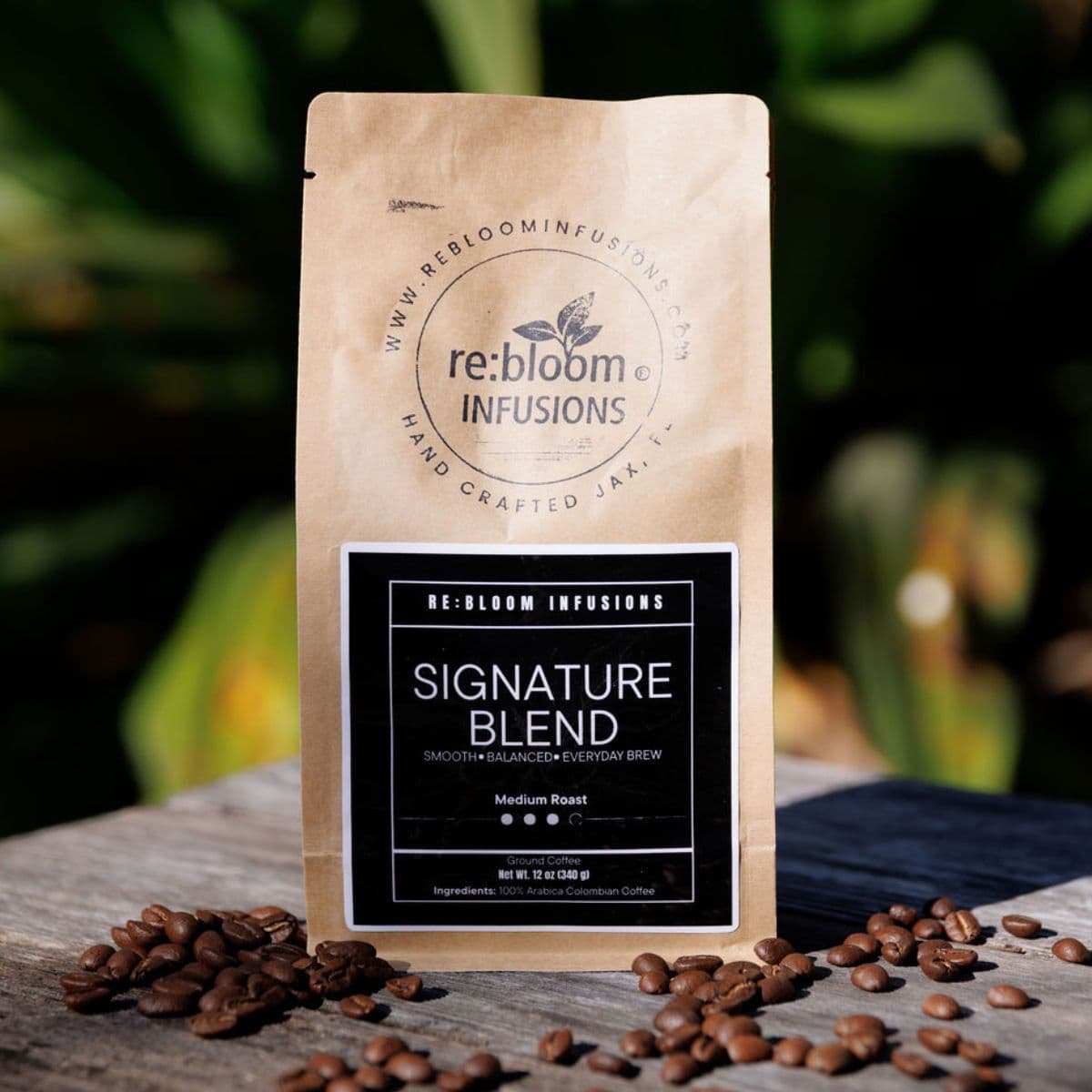 Signature blend coffee medium roast by Rebloom Infusions with whole coffee beans on wooden table